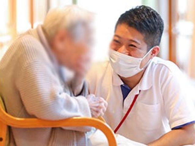 談笑するスタッフと入居者 スタッフイメージ スタッフと入居者の温かい交流を感じる場面があります。互いに安心感を持てる職場環境です。
