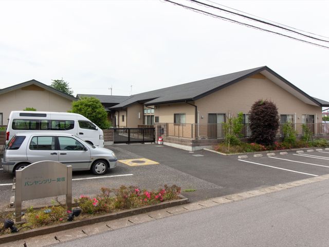 平屋建ての建物外観 外観 ゆったりとした駐車場と清潔な外壁が、心地よい雰囲気を演出しています。