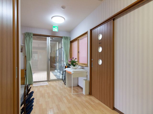 明るく清潔な廊下 玄関ホール 木目調のドアと床が温もりある空間を演出し、快適な通路が確保されています。