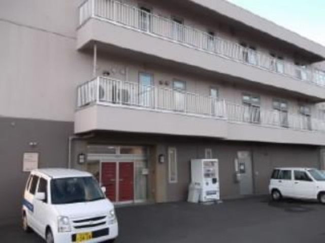 建物外観と駐車スペース 外観 赤いドアが印象的な外観です。清潔感のある建物で、来訪者にも心地よい印象を与えることでしょう。