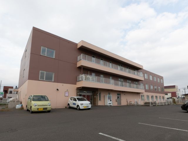 建物の外観と駐車場 外観 広々とした駐車スペースのある落ち着いた色合いの建物です。気持ち新たにお仕事を始める環境としてご検討ください。