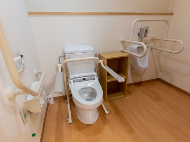 バリアフリー設計のトイレ トイレ 手すりと広々としたスペースをもつ安全なトイレです。利用者の自立を支えるための配慮がされています。