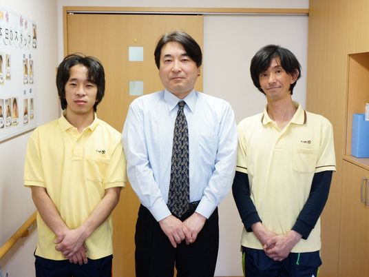 スタッフ三人立つ廊下端