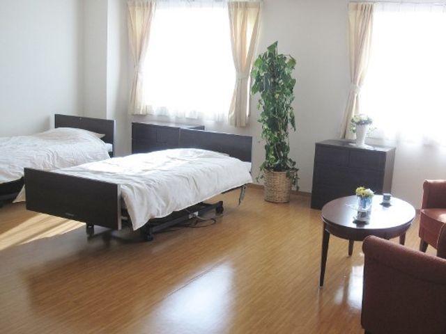 居室の明るい雰囲気 居室 二つのベッドが置かれた広々とした部屋で、日光がたっぷりと差し込む快適な居住空間です。温かみのあるインテリアが訪れる方々の心を和ませてくれます。