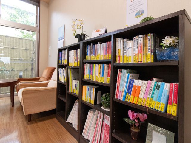 図書コーナーの安らぎ空間 リビングルーム ゆったりとした椅子と豊富な書籍で癒しの時間を提供する休憩スペースです。こちらで心地よい読書を楽しむことができます。