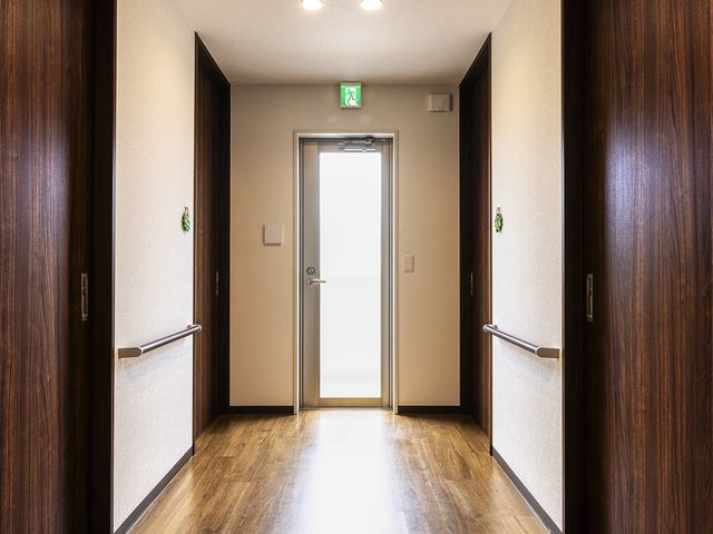 明るく清潔な廊下 廊下 手すりが備わった安全な通路です。壁には温かみを感じさせる飾りや掲示物があり、居心地の良い環境が整っています。