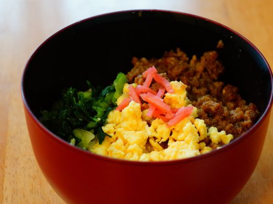 赤い丼に盛られた食事