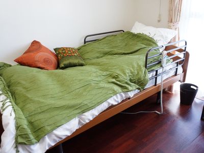 緑のベッドカバーの居室