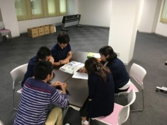 会議室の机を囲む人々  