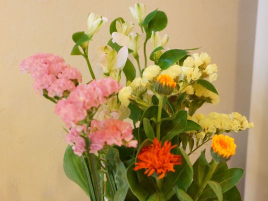 ピンク、オレンジ、黄色に白など、色も形も異なった花々が１カ所に生けられている。花は綺麗に咲き誇っている。
