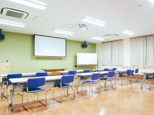 訓練用の机椅子が並ぶ多目的室  