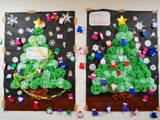 クリスマス飾りの壁面 展示物 手作りのクリスマスツリーが壁を飾り付けており、季節のイベントを楽しむ温かい雰囲気が感じられます。色とりどりの飾りが、明るく楽しい空間を演出しています。