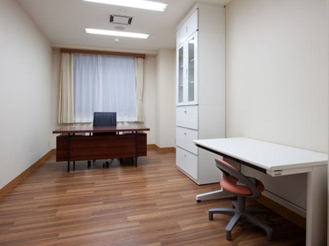 机と椅子が配置された部屋 居室 広々とした空間に、デスクと椅子が配置されています。落ち着いた色調で作業しやすい環境です。