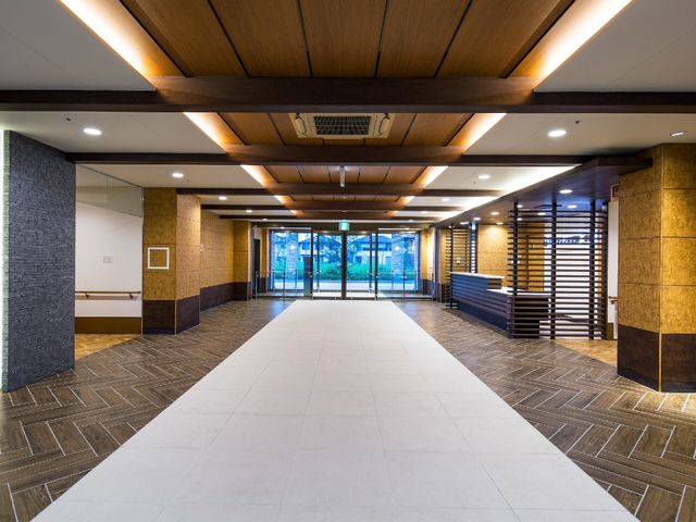 広々とした廊下の風景 廊下 落ち着いた色合いの床と天井が印象的な廊下では、働きやすい環境が整っています。明るく開放感のある設計です。