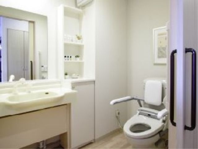 清潔な洗面所とトイレ 洗面台・トイレ 手すり付きのトイレと洗面台が整った清潔感のある空間です。ゆとりを持ってご利用いただけます。