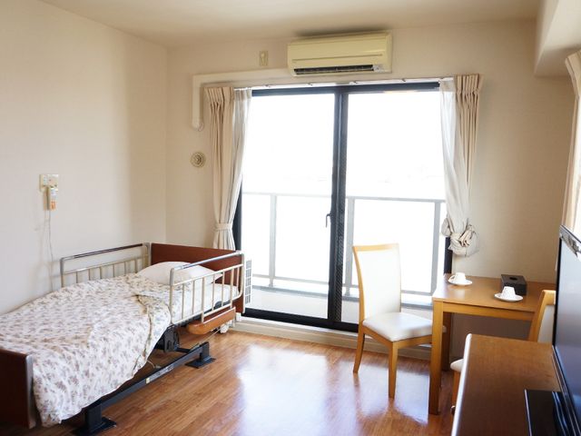 快適な居室の様子 個室 ゆとりある居室で、個々の時間を大切に過ごしていただけます。日差しが差し込むベランダへの扉もあり、開放感がございます。