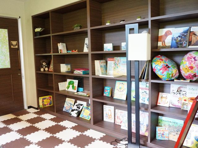 多彩な本のある棚 休憩所 落ち着きのあるスペースには、バラエティ豊かな図書と可愛らしい装飾が並び、ご利用者の憩いの場になっています。