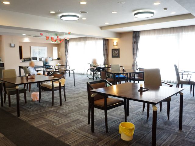 広々とした共用ダイニング リビング ゆったりしたダイニングルームで、居住者が心地よく食事を楽しんでいます。明るい照明と清潔感のある環境で、交流の場としても最適です。