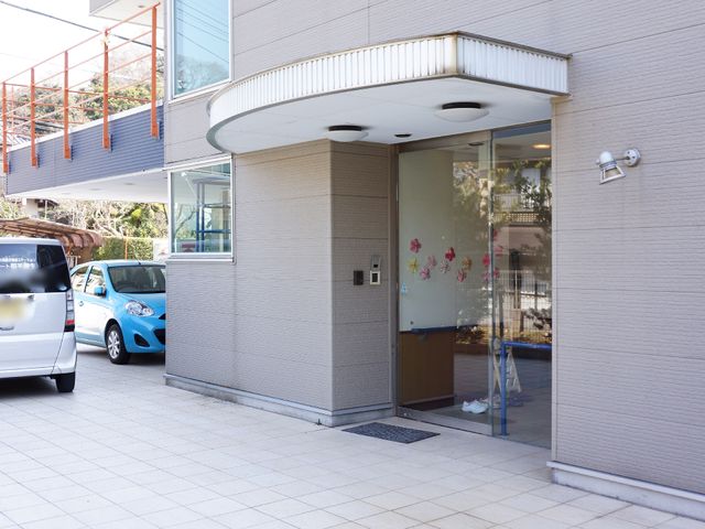 エントランスの様子 玄関 広々としたエントランスは明るく開放感があり、壁面の花飾りが訪れる人を優しく迎えています。車イス使用者も安心して通れるような造りになっており、暖かい印象を受けます。