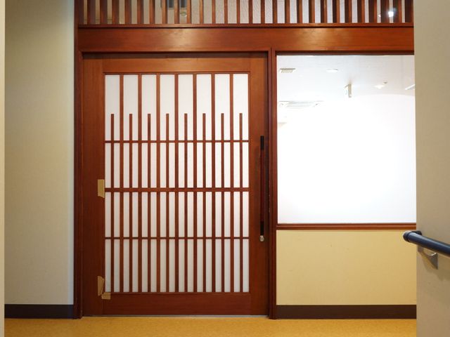 和風の木製引き戸 和を感じさせる引き戸 暖かみのある木目と伝統的なデザインが印象的な和風の引き戸が設置されており、静かで落ち着いた雰囲気を感じさせます。