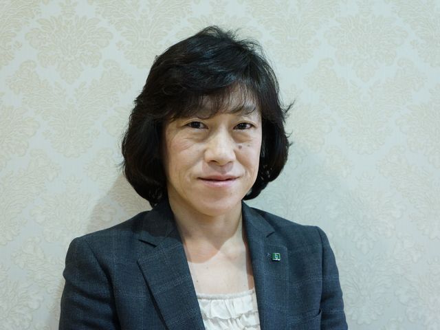 女性スタッフのポートレート スタッフ紹介 笑顔でお出迎えするスタッフの姿が印象的です。温かみのある接客が、皆様の業務を支えます。