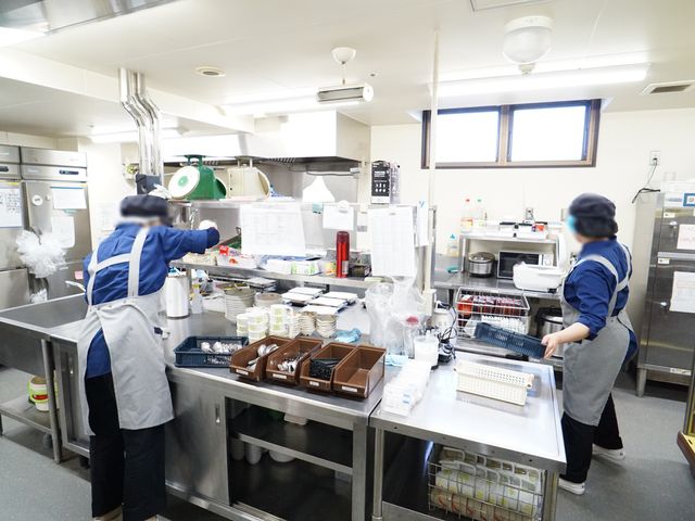 清潔な厨房の様子 キッチン スタッフが丁寧に作業を行っているキッチンです。衛生的な環境での調理が、働く方々のやりがいにも繋がっています。