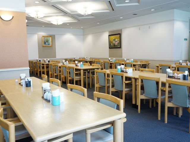 明るいダイニングルーム ダイニング 広々とした食堂で、落ち着いた色調の家具が整然と配置され、共有の食事時間を快適に過ごせる環境が整っています。