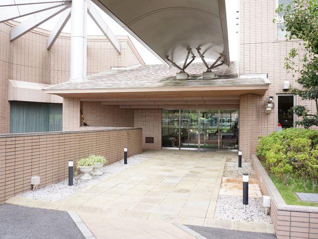 広々としたエントランス エントランス 広く開放的な入り口は、来訪者を温かく迎え入れる設計です。落ち着いた色合いの建物が、上質な環境を提示しています。