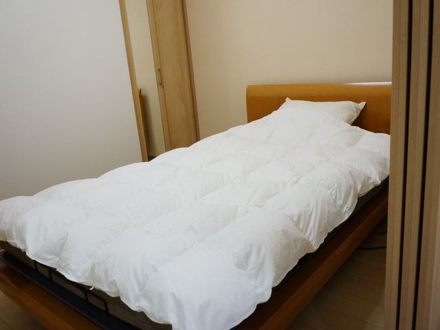 清潔なベッドのある部屋 ベッド シンプルで落ち着いた雰囲気の居室です。快適な休息を支える環境を備えております。