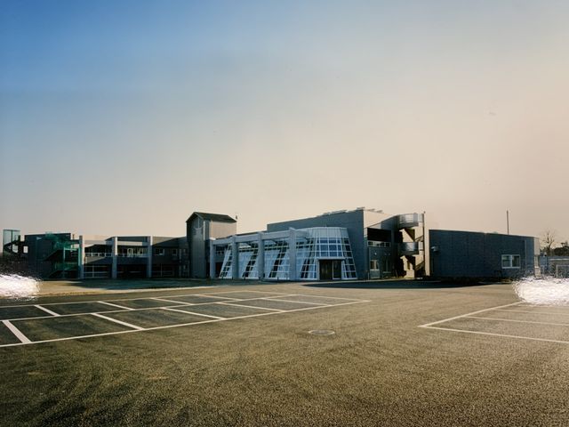 広い駐車場の建物外観 外観   広々とした駐車場がある建物です。通勤時の駐車がしやすく、スタッフには嬉しい環境です。