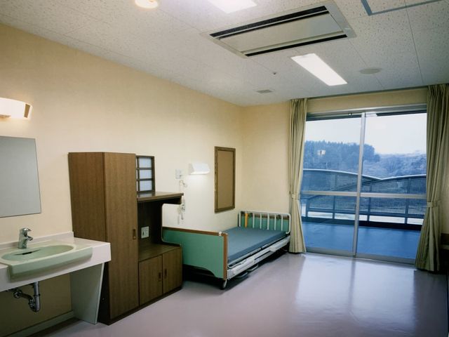 ベッドと洗面台の居室 居室 広々とした窓から自然光が入る明るい部屋です。清潔感のある環境で快適に過ごせます。