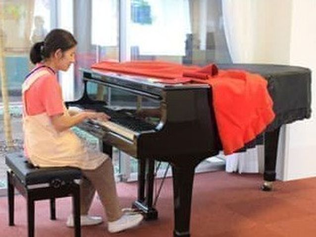 親しげなピアノ ラウンジ 暖かみのあるラウンジに設置されたピアノを楽しむ光景です。くつろぎながらリラックスできます。
