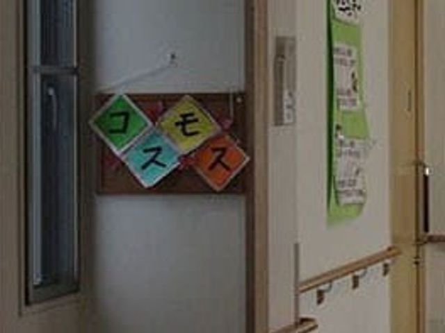 「コスモス」掲示板 廊下 廊下にある「コスモス」の掲示物が居室の目印となり、温かみを感じさせる空間です。