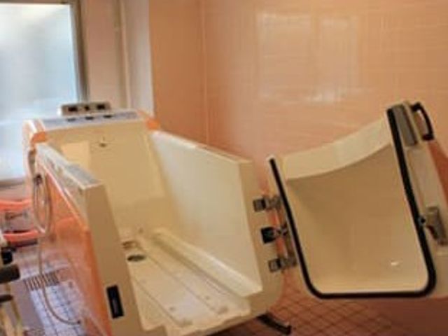 パステルピンクの安心感ある浴室 浴室 機械式浴槽が設置された明るい空間です。介助が必要な方も安心して使用できる設計です。