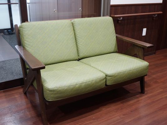 緑色のソファが置かれた廊下