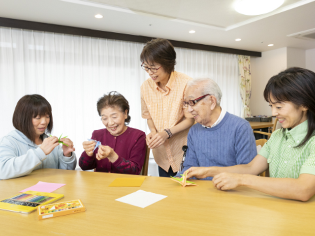 手工芸を楽しむ居室 明るく穏やかな雰囲気の中で、手工芸に親しむ利用者の姿が見受けられます。共に過ごし、創作活動を楽しむ空間です。