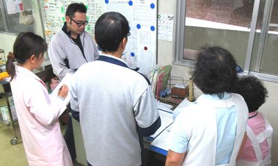 受付で書類を確認する人々