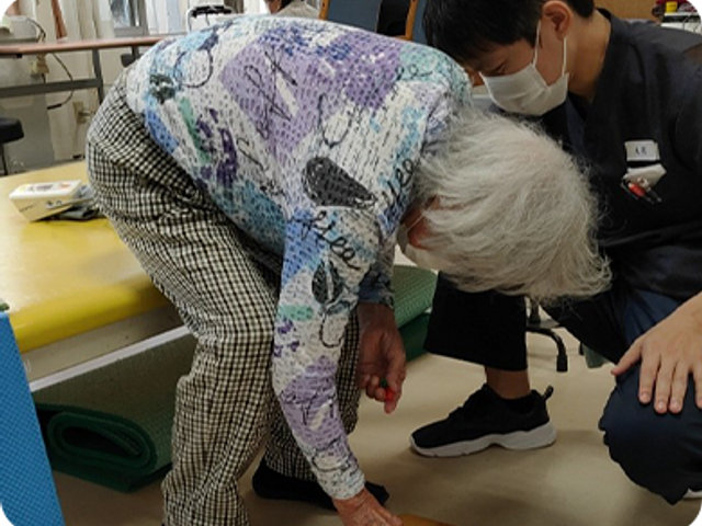 機能訓練中の様子 機能訓練室 高齢の方がスタッフと一緒にリハビリを行っています。身近でサポートが受けられます。
