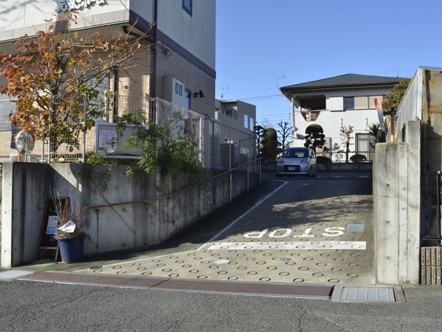 スロープのある出入口 外観 広いスロープがあるため、車椅子の方も安全に出入りできます。入口付近には季節の植物も見られます。