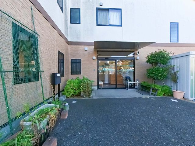 エントランス正面 エントランス 入口は広く、車椅子での出入りもスムーズです。植物が配され、落ち着いた雰囲気です。