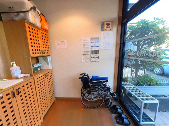 車椅子と掲示物のあるエントランス エントランス 自然光が差し込み、開放感のあるエントランスです。安全情報が壁に掲示されています。