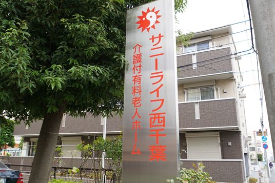 施設の看板前の風景