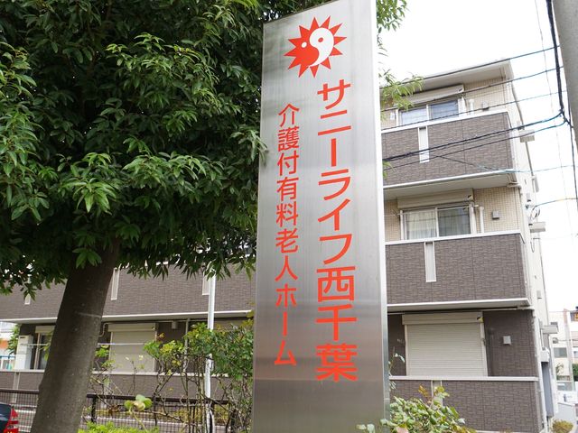 施設の看板前の風景 ロゴ 明確な情報を示す表記が目に留まり、周囲の環境も落ち着いた雰囲気です。