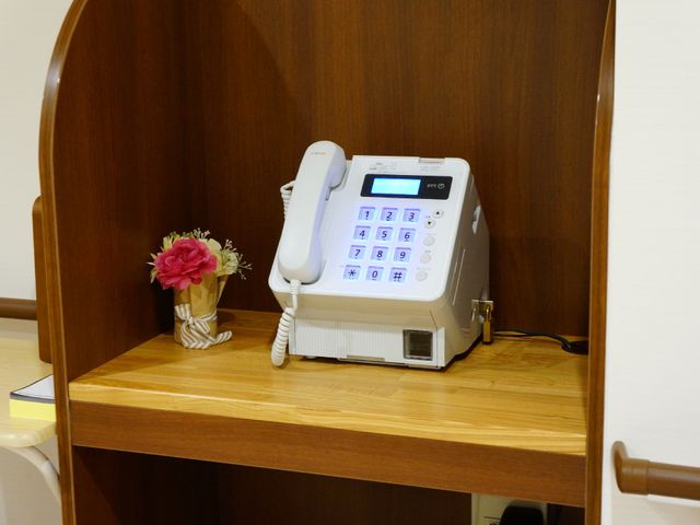 電話と花飾りのデスク 公衆電話 心温まる工夫がされた居室の一角です。こまやかな配慮が施された快適な空間で、ゆったりと過ごせます。