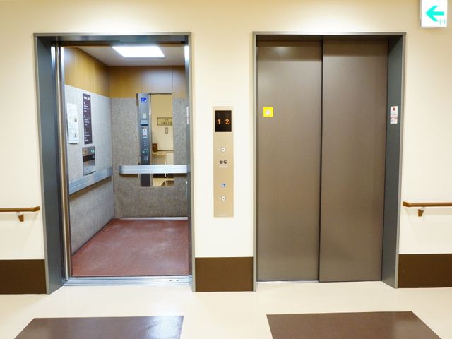 廊下とエレベーターの風景 2基のエレベーター 広々とした廊下には、スムーズな移動を支援するエレベーターが設置されており、バリアフリー設計が施されています。明るく清潔感のあるこの通路は、日々の業務に安心感を与えてくれるでしょう。