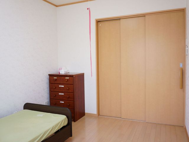 居室のベッドとタンス 居室 落ち着いた色合いの居室です。必要な家具と広々とした空間が確保され、安心して過ごせる環境が整っています。