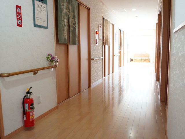 清潔感のある明るい廊下 通路 陽の光が差し込む温かみのある廊下は、安心感を与える落ち着いた色調で統一されています。手すりが設置されており、安全に配慮された設計です。