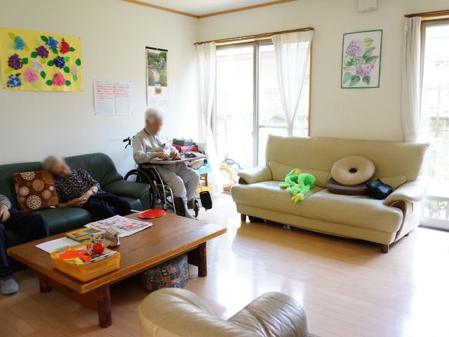 居心地の良いリビング 共有スペース 日差しのあたたかい共有リビングで、くつろぐ利用者の姿が見受けられます。様々な趣向を凝らした装飾が心地よい空間を演出しています。