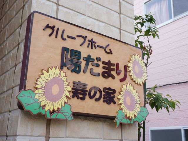 ひまわりの装飾看板 看板 温もりあふれる看板がお出迎え。ここは、訪れる人々に明るさと安らぎを提供する場所です。