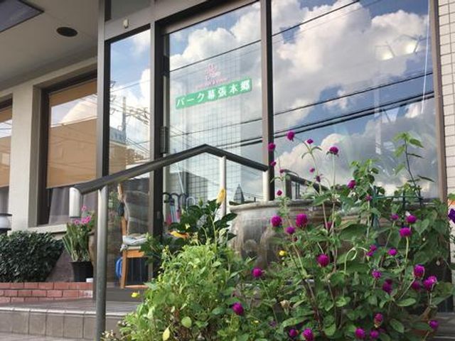 看板が見える玄関前 外観 季節の花々が彩る玄関は、訪れる人々を温かく迎えてくれます。爽やかな雰囲気が魅力的です。